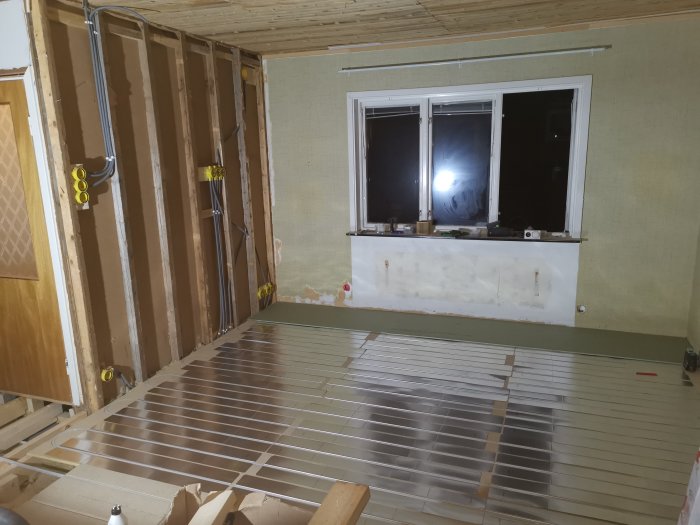 Renoveringsprojekt med avtäckt golv och väggisolering samt fönster.