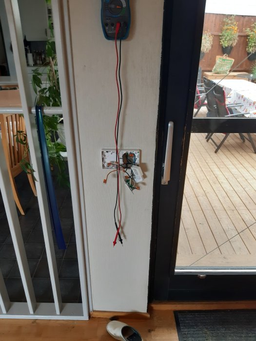 Öppet eluttag och lösa kablar vid dörrkarm, frustration med gardinfäste antyds.
