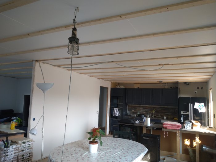 Renoverat kök med nya träreglar på taket för innertak, elinstallationer och befintlig köksinredning.