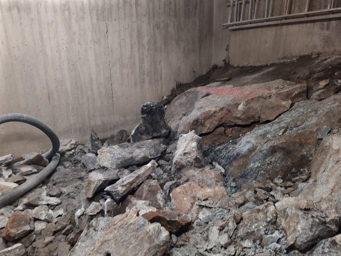 Efterspräckning i byggprojekt med berg och rasmassor samt markerade borrplatser.