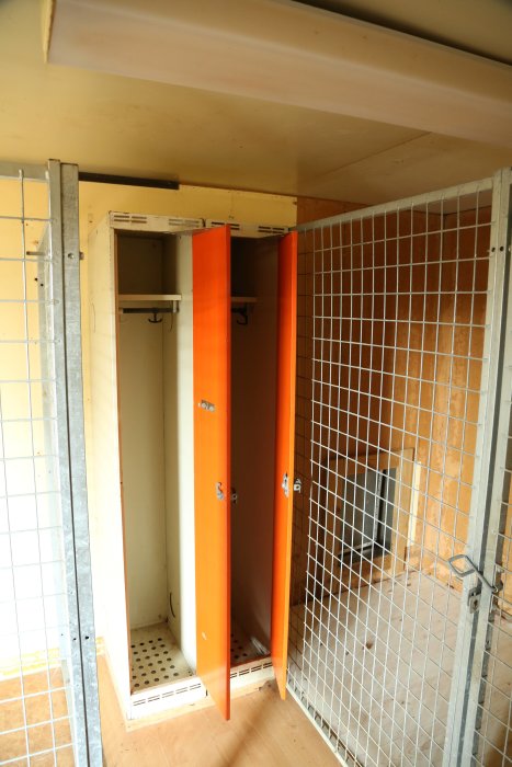 Inredning med orange klädskåp och stålnät i hundhuset som är till salu.