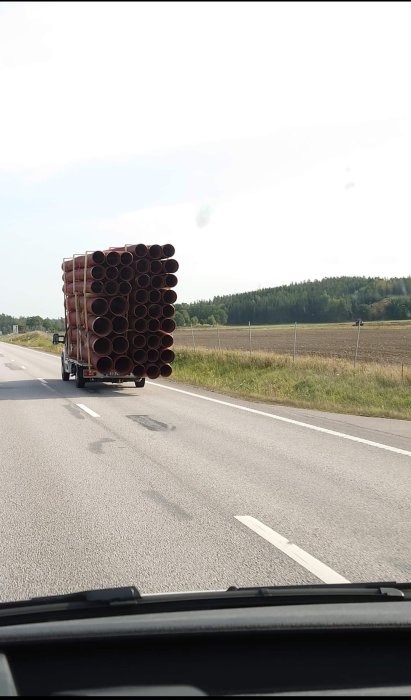 Lastbil med överhängande rörstack kör på E22S.