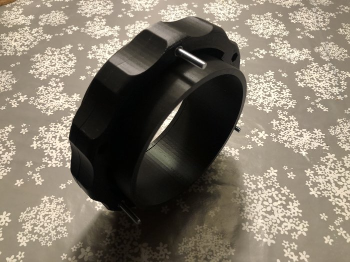 3D-utskriven svart PLA-koppling med låsring för slang till hyvel på mönstrad yta