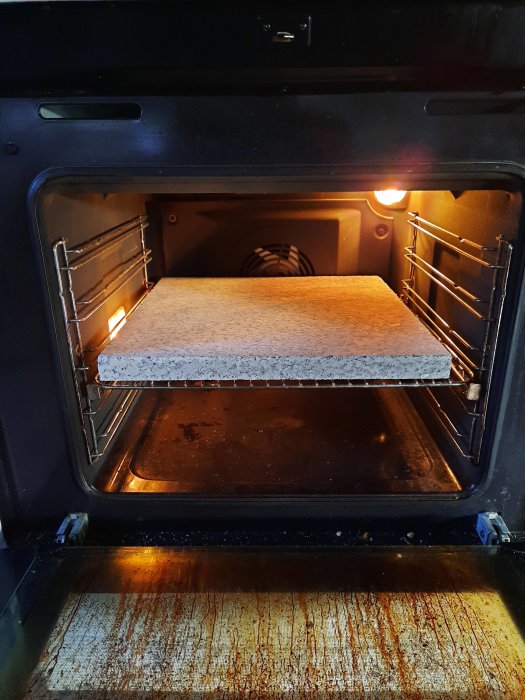 Två pizzastenar i en öppen ugn, redo för bröd- och pizzabak.