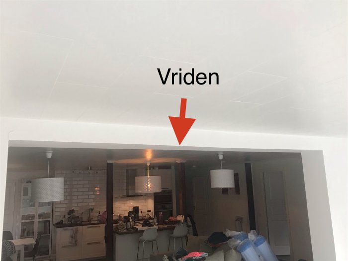 Inre vy över kök med synlig vriden takbalk markerad med en röd pil, vilket indikerar ett av de nämnda felen från byggprojektet.