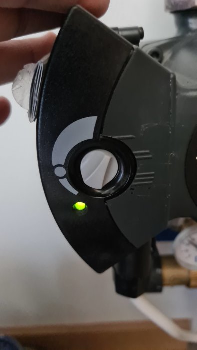 Närbild av justeringsreglage inställt på 'I', grönt ljus indikerar ström på.
