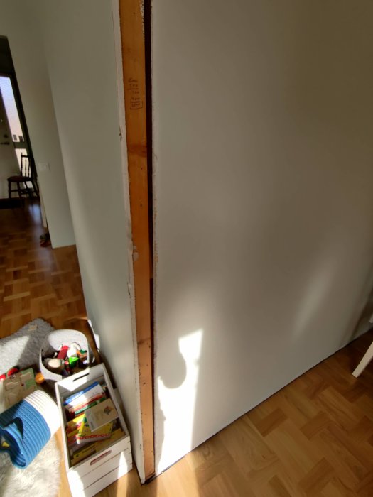 En vit vägg där en regel syns i en öppning, med barnleksaker i förgrunden.