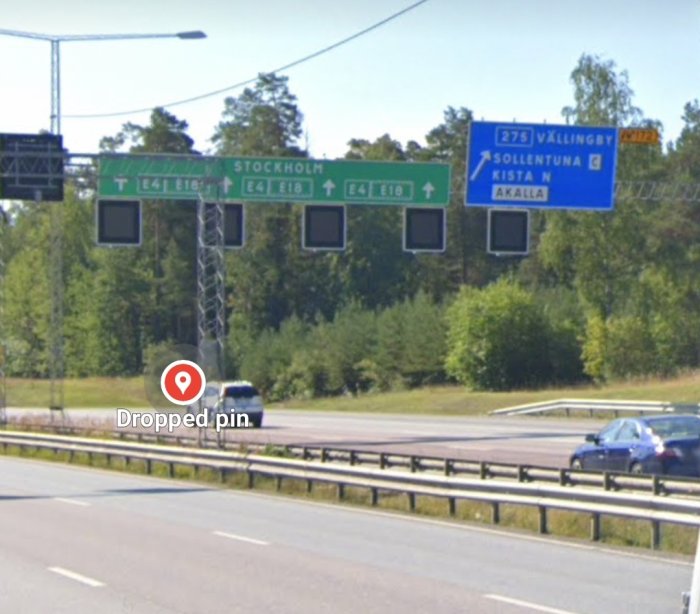 Vägskyltar visar riktningar för E4/E18 mot Stockholm och väg 275 mot Vällingby, Sollentuna och Kista.