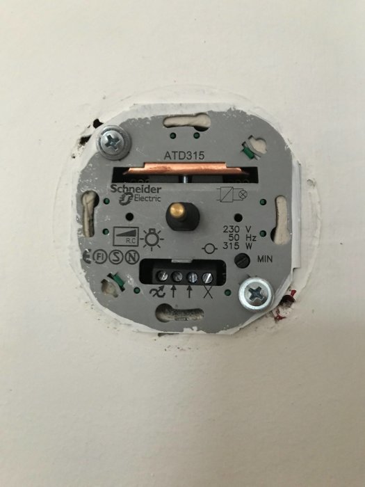 En öppen väggströmbrytare med en installerad 315W Renova transistor-dimmer som är redo att ersättas.