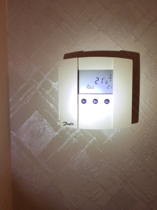 Termostat som visar 21 grader Celsius inomhus och 60 grader framledningstemperatur.