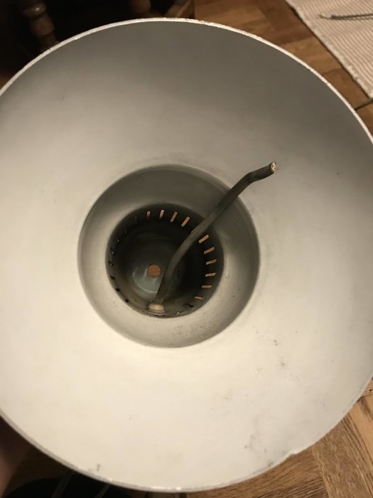 Inuti en klassisk skrivbordslampa som behöver renoveras med synlig rost och defekt lamphållare.