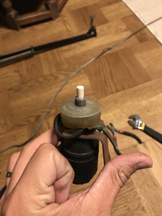 Renovering av en klassisk skrivbordslampas lamphållare med rost och synlig sladd i bakgrunden.