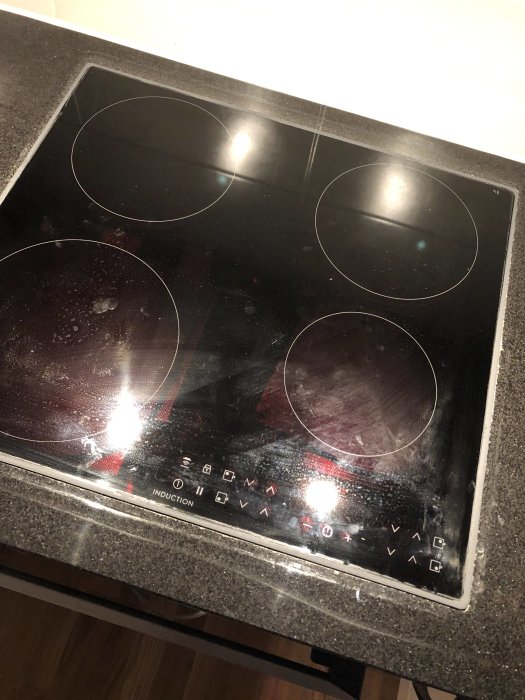 Induktionshäll installerad i bänkskiva med synlig glipa efter borttagen ram.