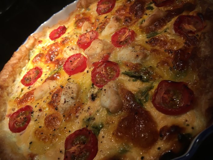 Hembakad laxpaj med smördeg, rökt lax, mangold, cream cheese, chili, mozzarella och tomater.