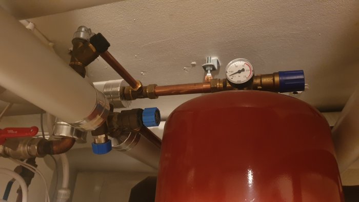 Expansionskärl och rörinstallation med manometer visande tryck, säkerhetsventiler och kopplingar.