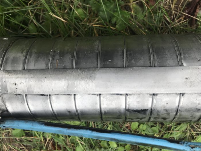 Skadad brunnspump med repor i radiell riktning och en avskalad kabel synlig, vilket tyder på mekanisk påverkan.