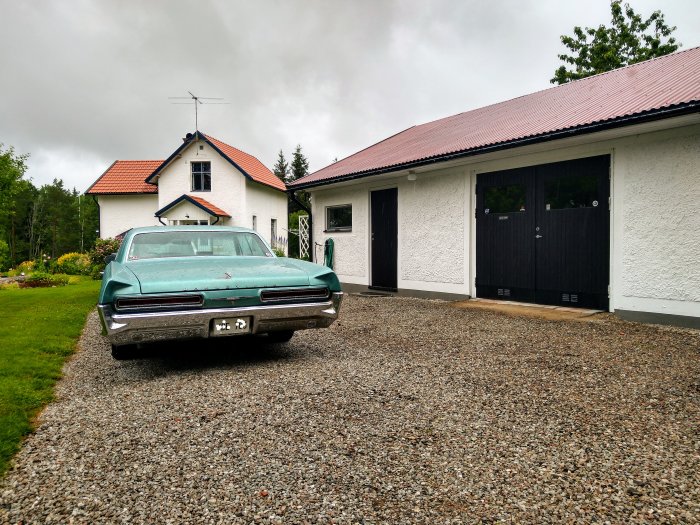 En grön 1966 Bonneville parkerad framför ett hus med 20-talsstil.