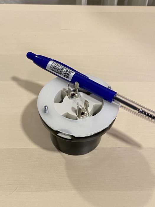 Ifö-lampsockel med kopplingsplint bredvid en blå kulspetspenna på ett ljust underlag.