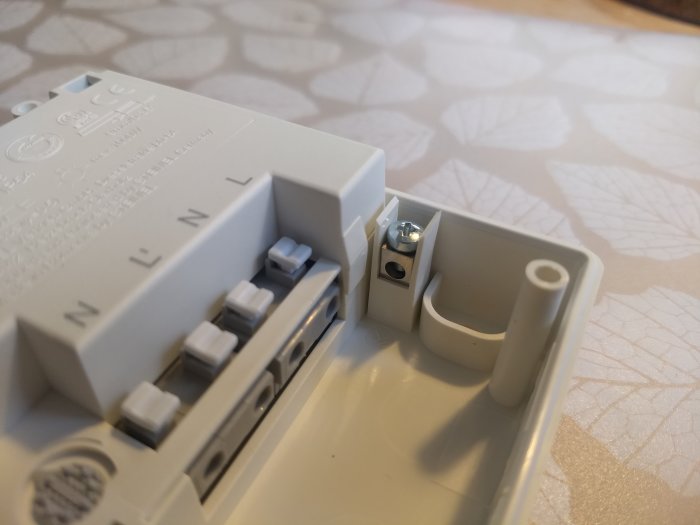 Elektrisk apparat med oansluten jordplint mot bakgrund av texturerad yta.