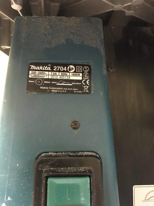 Närbild på Makita 2704 klyvsågs typskylt med tekniska specifikationer och användningsspår.