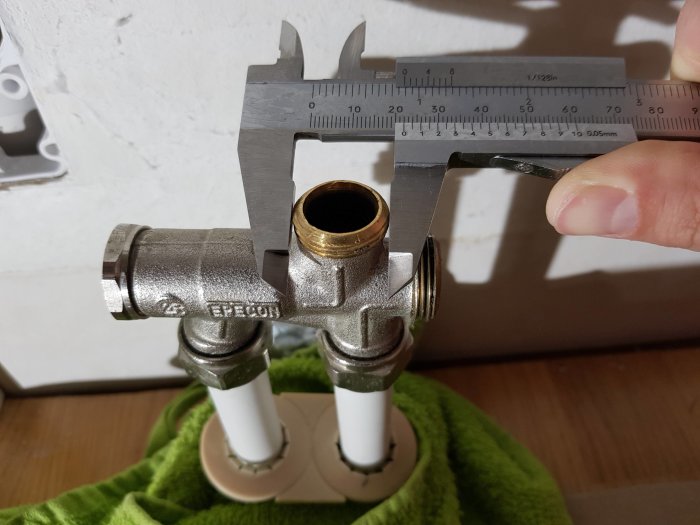 Mätning av radiatorrörets gänga med skjutmått för att hitta rätt storlek på plugg.