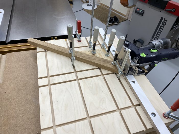 Snickerijigg monterad på arbetsbänk med en Festool Domino används för precision i träprojekt.