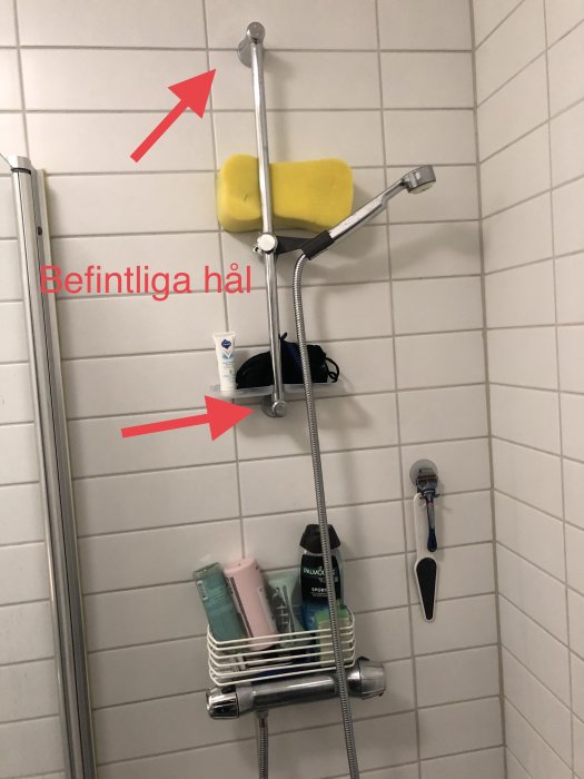 Duschstång med tvålfack monterad på kakelvägg med befintliga hål markerade, fråga om installation.