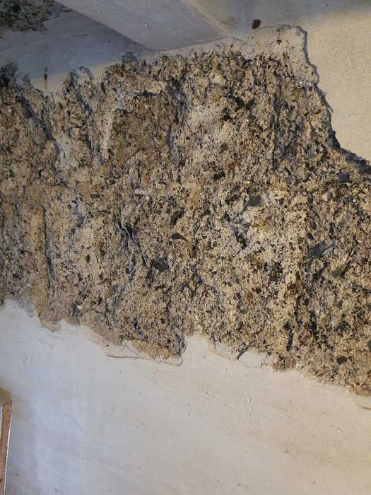 Väggrenovering med frigolit inlimmat i djupa hål och applicerat c-bruk, inga sprickor synliga.