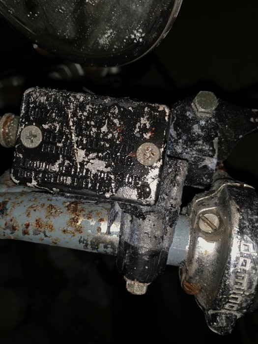 Närbild av en rostig och smutsig skivbroms på en moped