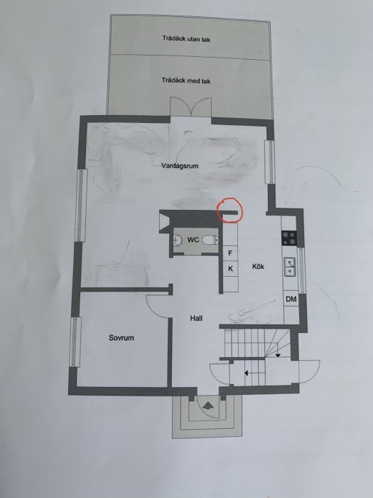 Planritning av en bostad markerad med en röd cirkel kring en vägg nära köket indikerar diskussion om eventuell rivning.