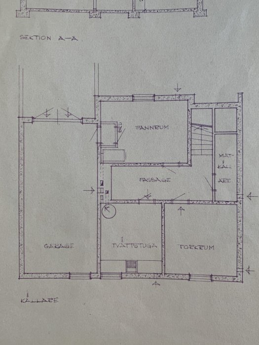 Arkitektritning över källarvåningen i ett tegelhus från 1957 med utmärkta rum som garage och pannrum.