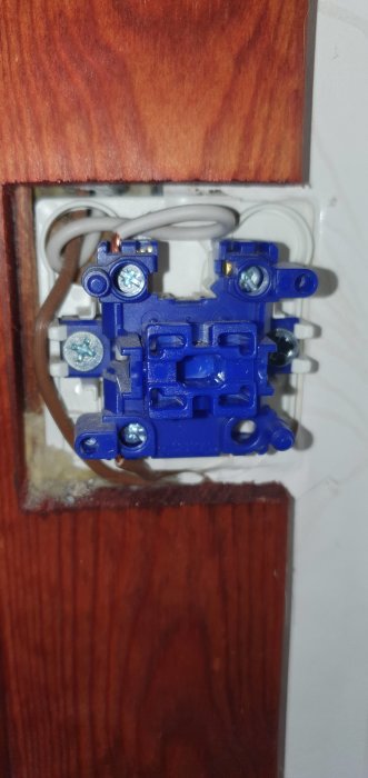 Öppen elinstallation med frilagd strömställare och synliga ledningar på vägg.