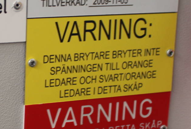 Varningsskylt som informerar om att brytaren inte bryter spänningen till alla ledare i skåpet.