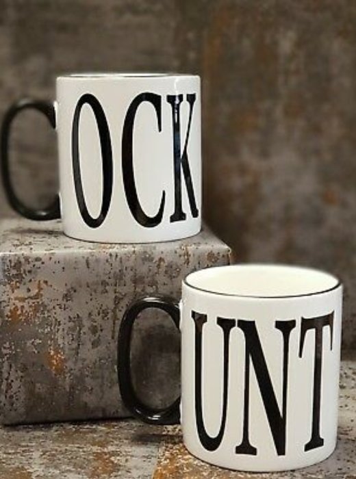 Två vita kaffemuggar med bokstäverna "COCK" och "UNT" på ett rostigt underlag.