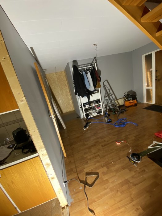 Nästan färdigt innertak i rum under renovering med stege och byggmaterial på golvet.
