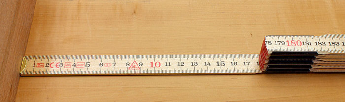 Måttband utdraget över en träyta som mäter längd, fokus på siffrorna 8 till 18 cm.
