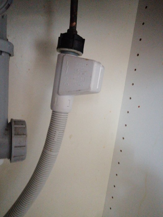 Aquastop ansluten till en rostig vattenledning under ett köksskåp.