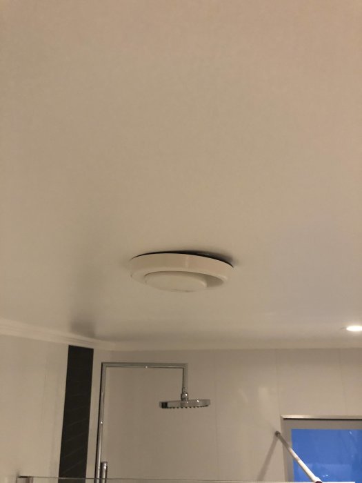 Bubbla i taket nära ventilationslock i badrum, tecken på möjlig fuktproblematik.