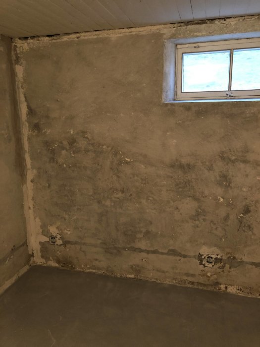 Vägg med borttagen färg och fläckar där färg sitter kvar, redo för lagningsbruk.