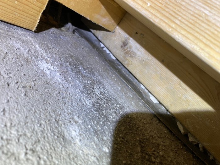Grund med träreglar som inte är gjutna i betong, med synlig sula och fiber- eller asfaltmatta.