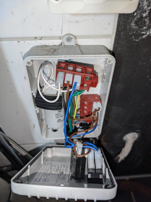 Eluttag med motorstyrning och kondensator ansluten till en tryckvakt, oanvänd blå kabel synlig.