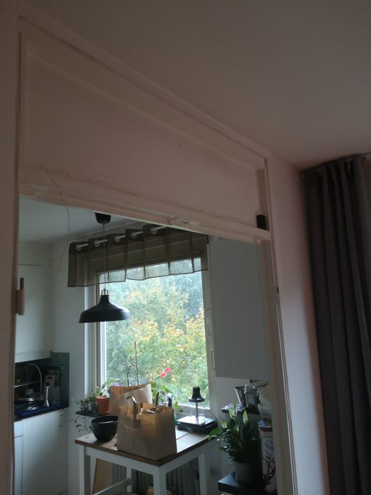 Delvis rivet tak och vägg mellan kök och vardagsrum med synligt äldre ventilationsrör.