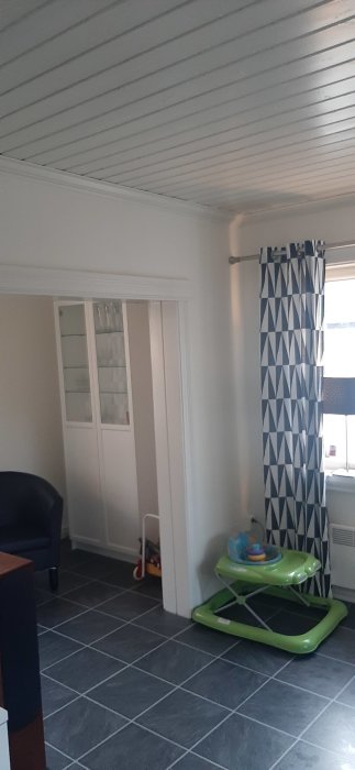 Vit vägg med dörröppning och vit paneltak i rum planerat för renovering.