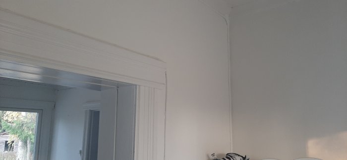 Vägg och tak i ett vardagsrum från 1933 med en öppning som kan vara del av en renoveringsplan.