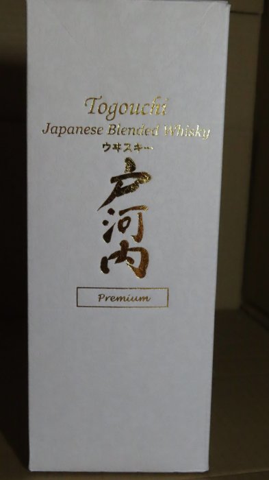 Flaska av Togouchi Japanese Blended Whisky i vit förpackning med guldtext.