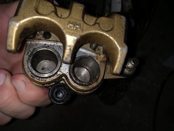 Närbild på en handhållen bromsokskomponent med slitage och korrosion.
