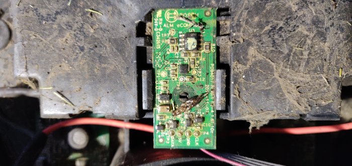 Kompasschip på kretskort med smuts och en död tvestjärt inuti en robotgräsklippare.