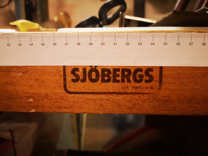 Måttband limmat på träsnickarbänk med texten "SJÖBERGS OF SWEDEN".