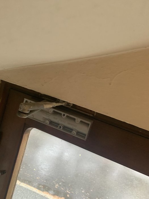 Monterad säkerhetskätting på en öppen dörrs ovansida.