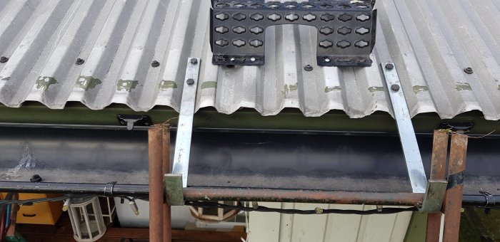 Närbild på ett plåttak med nymonterade, metalliska taksteg och förstärkta läktbitar för bättre fäste och stöd.